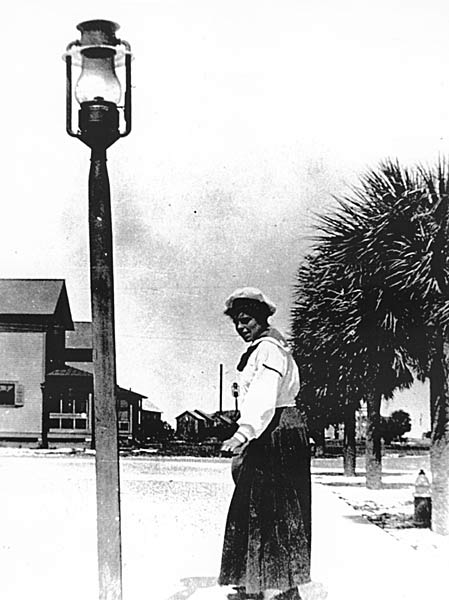 Woman standing by lamp post