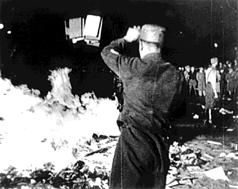 One way the Nazis cleansed the country of un-German thoughts was through censorship. A brown shirt (member of the SA) throws some more fuel -un-German books - into a roaring fire on the Opernplatz in Berlin. May 10, 1933.