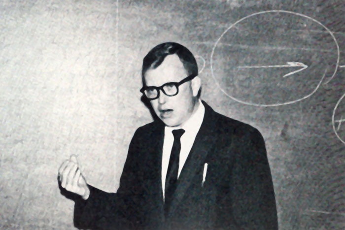Dr. William Bott in front of a chalk board