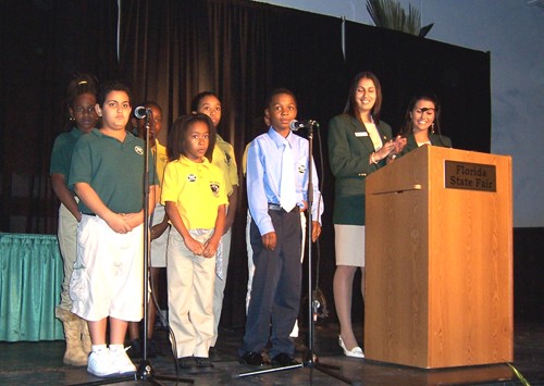 young students and teachers standing on stage