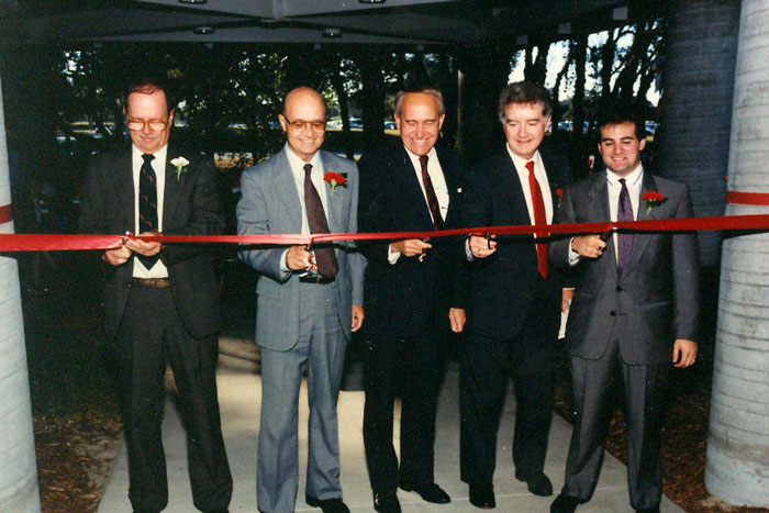 several people cutting a ribbon