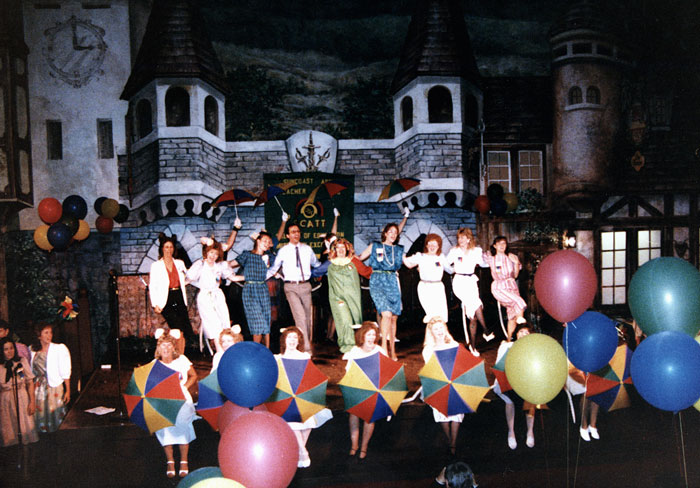 students dancing on stage in front of a castle