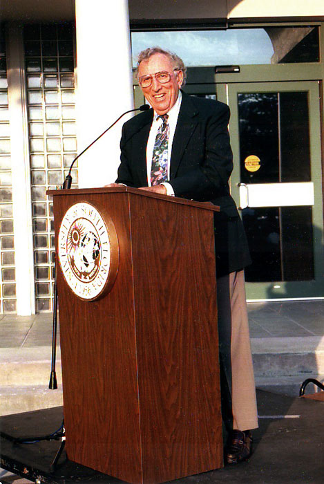 Dr. Gus A. Stavros standing at a podium